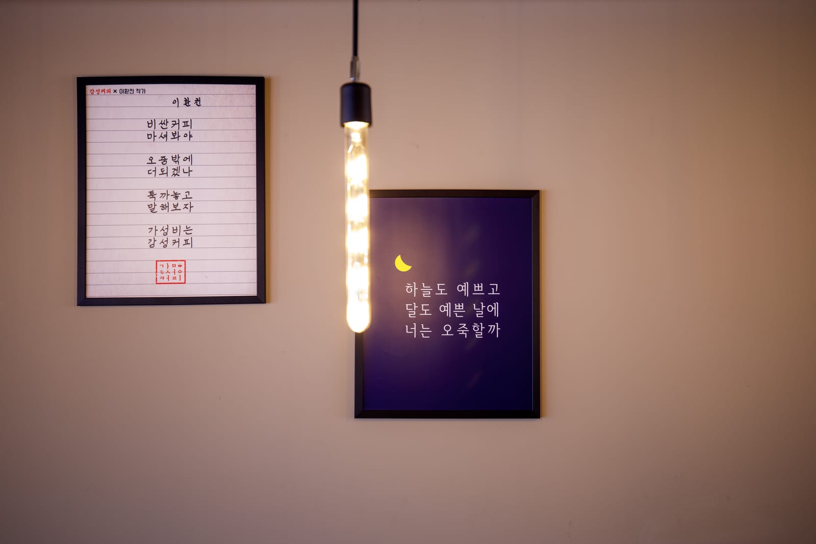 베이지 벽 액자와 펜던트 전구 조명
