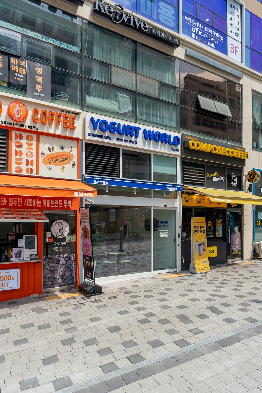 회색 블록타일 보도와 남색 톤 사인보드 입구